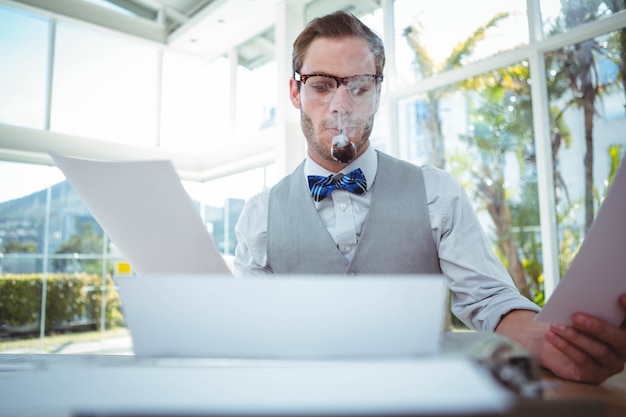 Hombre guapo con máquina de escribir antigua en oficina brillante