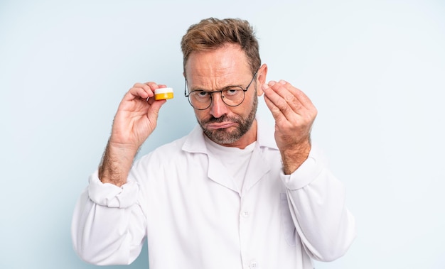 Hombre guapo de mediana edad haciendo capice o gesto de dinero, diciéndole que pague. concepto de lentes de contacto