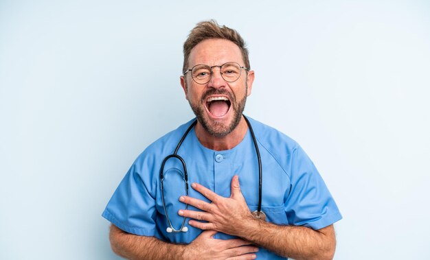 Hombre guapo de mediana edad riendo a carcajadas de una broma hilarante. concepto de enfermera
