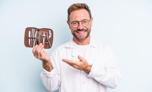 Hombre guapo de mediana edad sonriendo alegremente, sintiéndose feliz y mostrando un concepto. concepto de podólogo