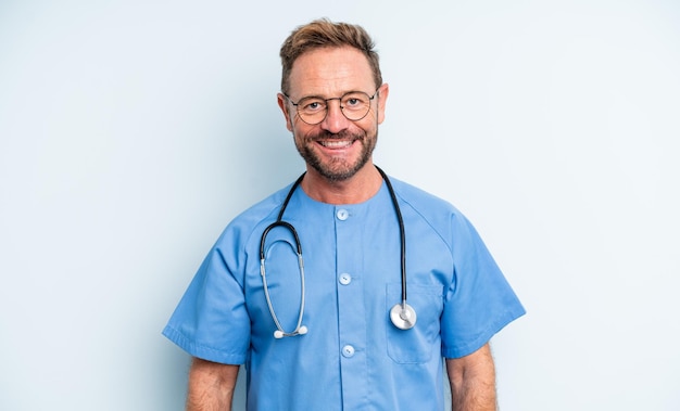 Hombre guapo de mediana edad sonriendo felizmente con una mano en la cadera y confiado. concepto de enfermera