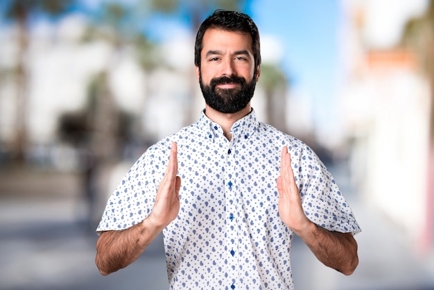 Hombre guapo morena con barba sosteniendo algo