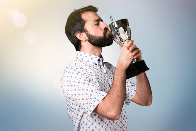 Hombre guapo morena con barba sosteniendo un trofeo