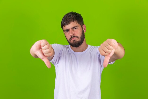 Foto hombre guapo mostrando signo negativo con el pulgar hacia abajo