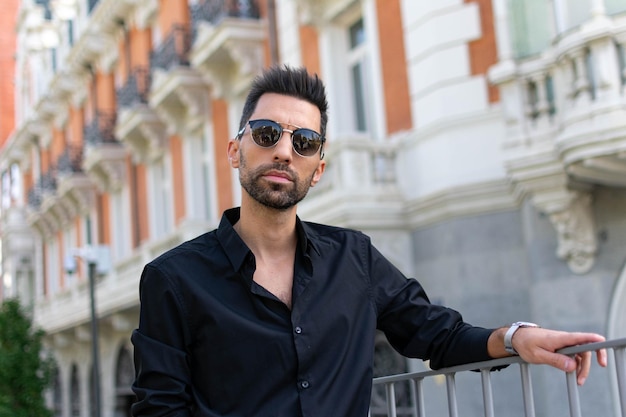 Hombre guapo de negocios de estilo barba de moda posando en ropa de estilo y gafas de sol de moda en la calle