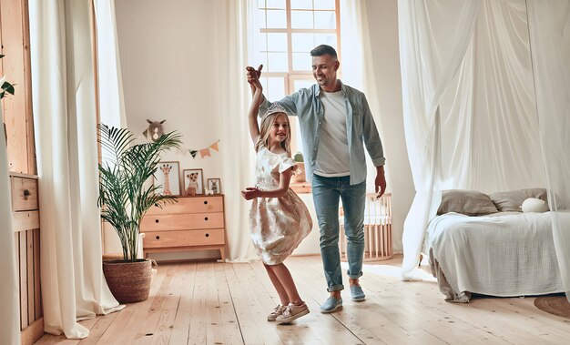 Hombre guapo pasando tiempo en casa con su linda hijita Feliz Día del Padre Papá e hija