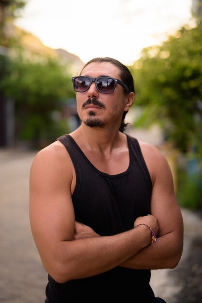 Foto hombre guapo con pelo rizado y bigote en las calles al aire libre