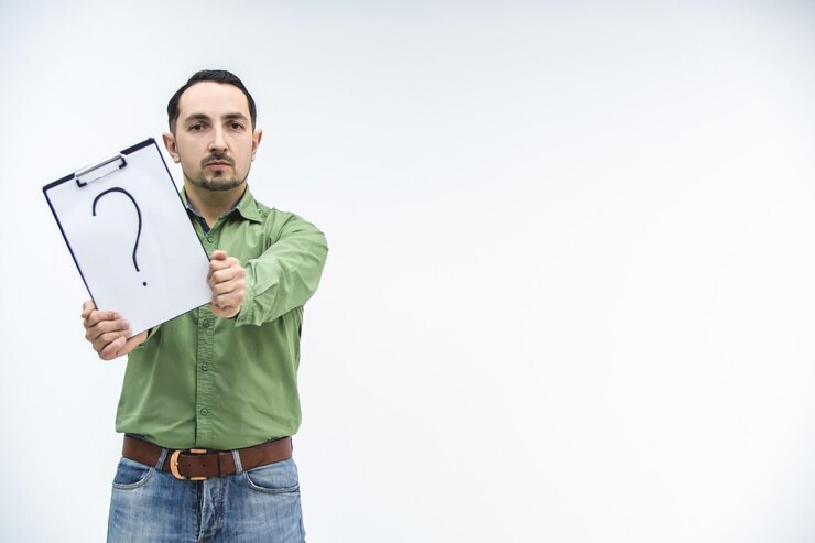 Foto el hombre guapo y pensativo que sostiene un signo de interrogación tiene demasiadas preguntas y ninguna respuesta.