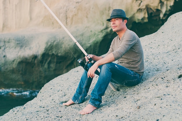 Hombre guapo pescando durante su día libre