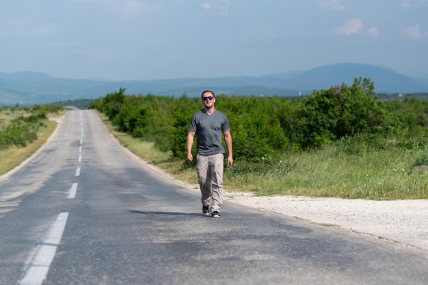 Hombre guapo de pie fuerte y posando al aire libre en Street Highway