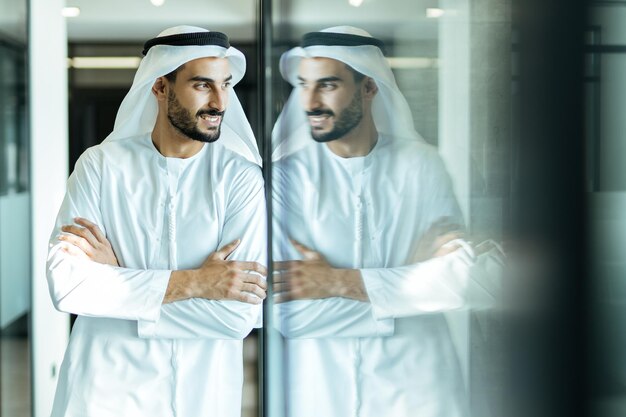 Hombre guapo con plato dasha trabajando en su oficina comercial de Dubai