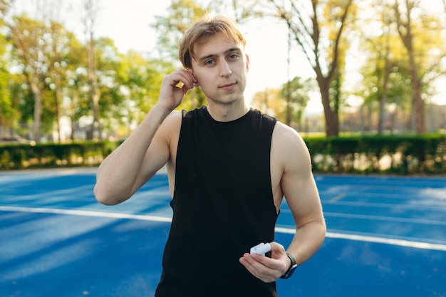 Hombre guapo se pone los auriculares durante el entrenamiento