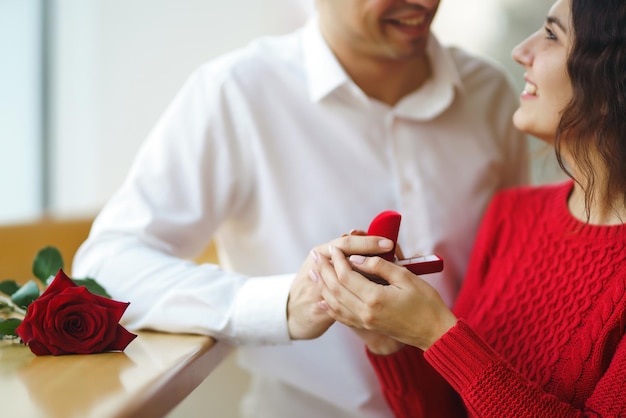 Hombre guapo proponiendo a una mujer hermosa que se case con él en el restaurante Concepto de celebración del día de San Valentín