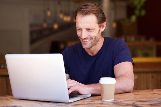 Hombre guapo que trabaja en la computadora portátil