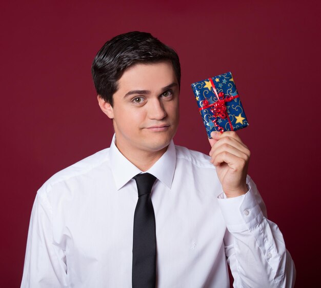 Hombre guapo con regalo. Disparo de estudio.