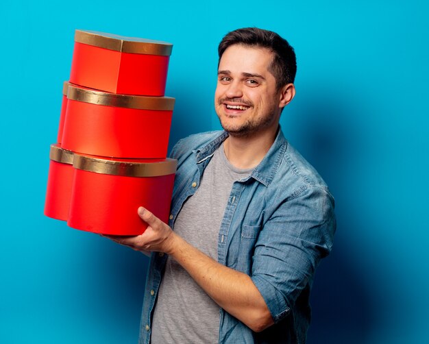 Hombre guapo con regalos rojos