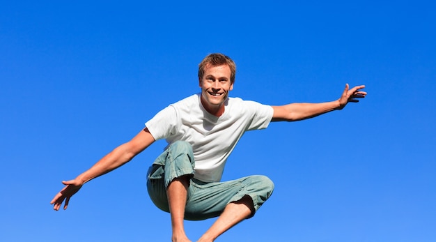 Hombre guapo saltando en el aire al aire libre