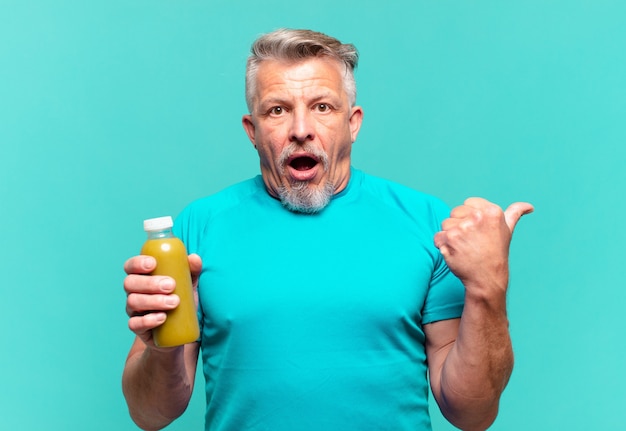 Hombre guapo senior bebiendo un batido vegano