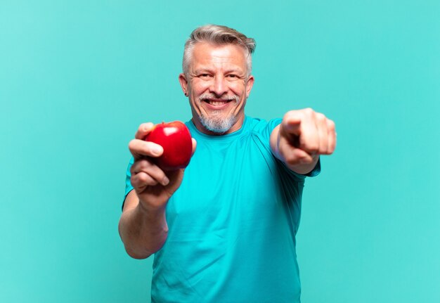 Hombre guapo senior con una manzana