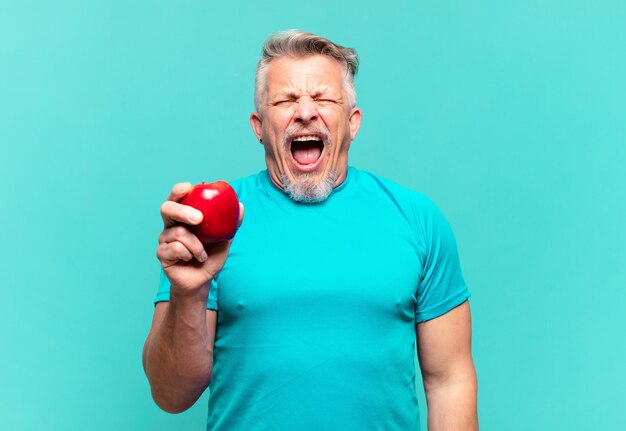 Hombre guapo senior con una manzana