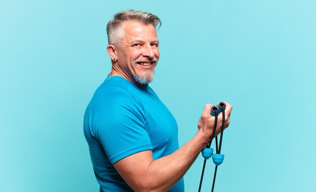 Hombre guapo senior practicando fitness y vistiendo ropa deportiva