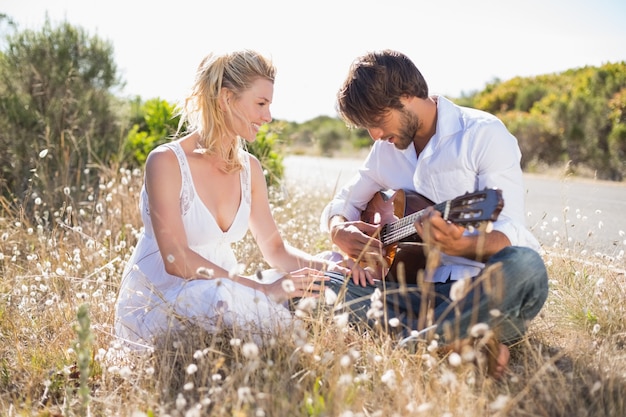 Hombre guapo serenata a su novia con guitarra