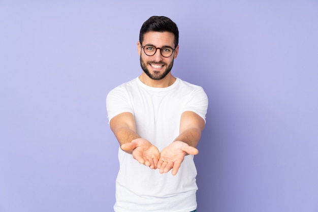 hombre guapo sobre la celebración de copyspace imaginario en la palma para insertar un anuncio