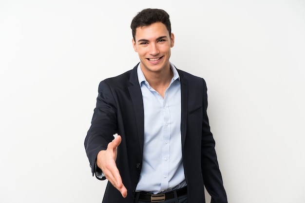 Foto hombre guapo sobre pared blanca aislada apretón de manos después de buen trato