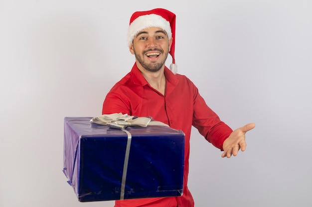 Foto hombre guapo con sombrero de santa claus y camisa roja con un regalo de navidad caja de regalo hombre navidad