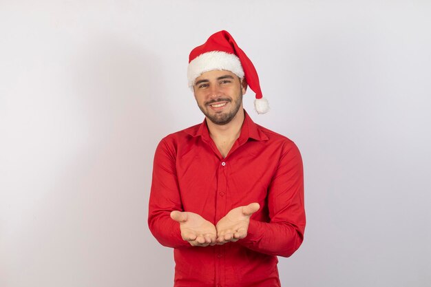 Hombre guapo con sombrero de santa llegando con algo