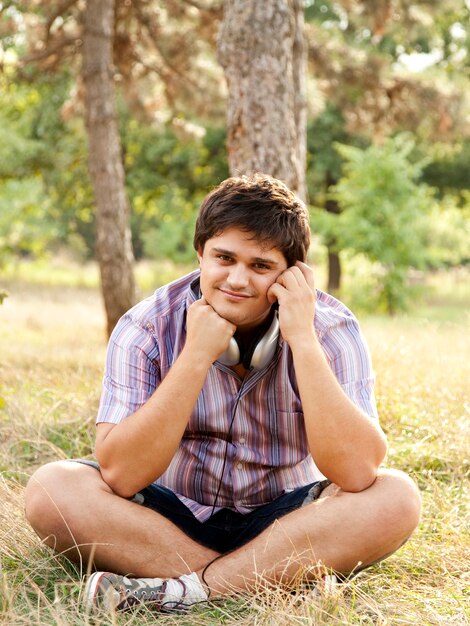 Hombre guapo sonriente con auriculares al aire libre