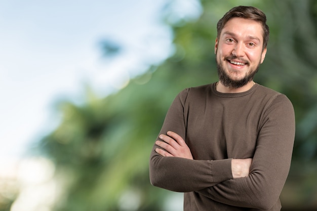 Hombre guapo sonriente barbudo con brazos cruzados