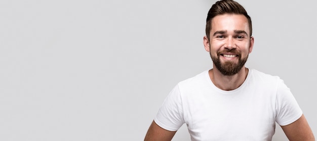 Hombre guapo sonriente en camiseta blanca con espacio de copia