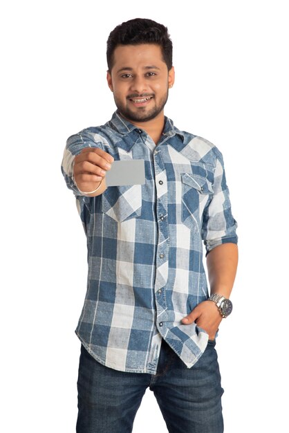 Hombre guapo sonriente joven posando con una tarjeta de crédito o débito sobre fondo blanco.