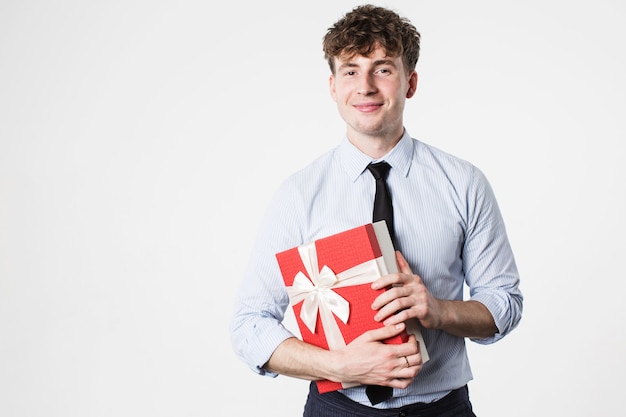 Hombre guapo sonriente con un regalo