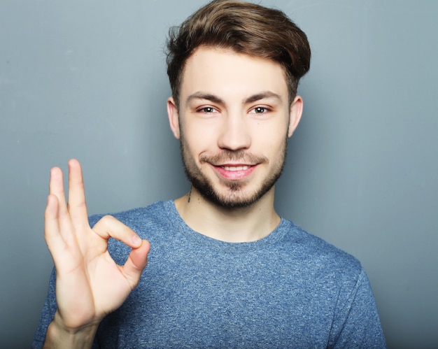 Hombre guapo sonrisa feliz, mano con signo de gesto ok