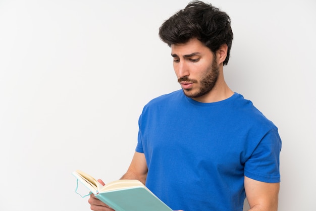 Hombre guapo sosteniendo y leyendo un libro