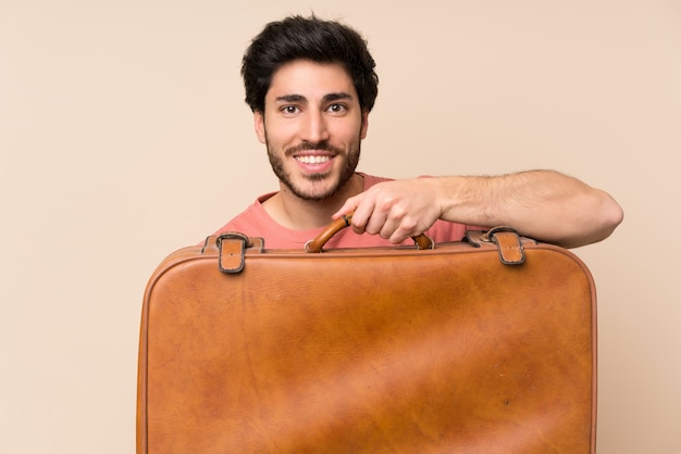 Hombre guapo sosteniendo un maletín vintage
