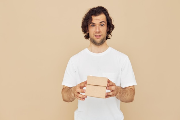 Hombre guapo sosteniendo una pequeña caja de cartón en sus manos