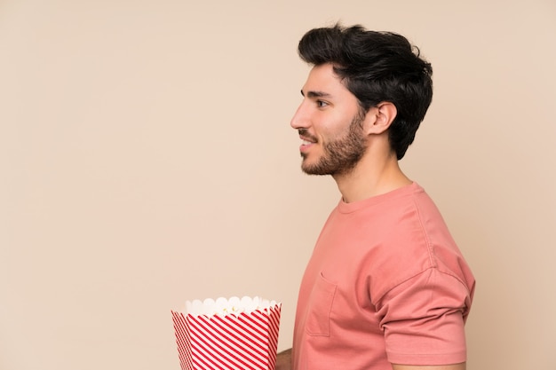 Hombre guapo sosteniendo un tazón de palomitas de maíz