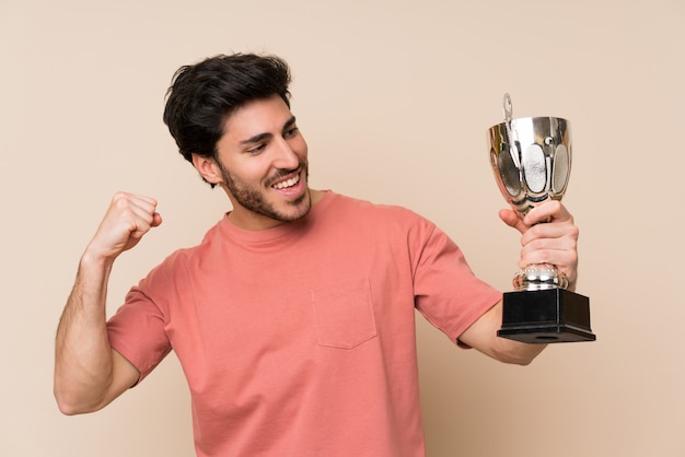 Hombre guapo sosteniendo un trofeo