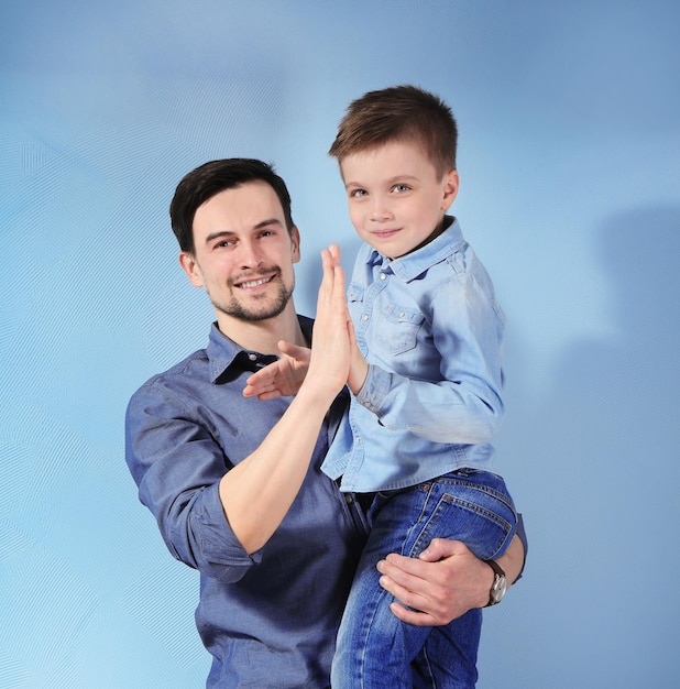 Foto hombre guapo y su hijo sobre fondo de color