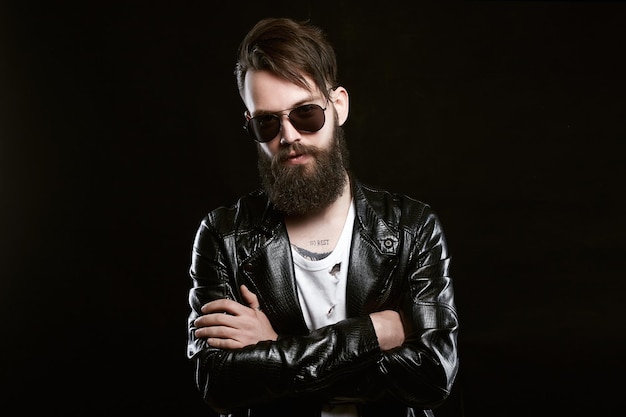 Hombre guapo tatuado de moda con gafas de sol