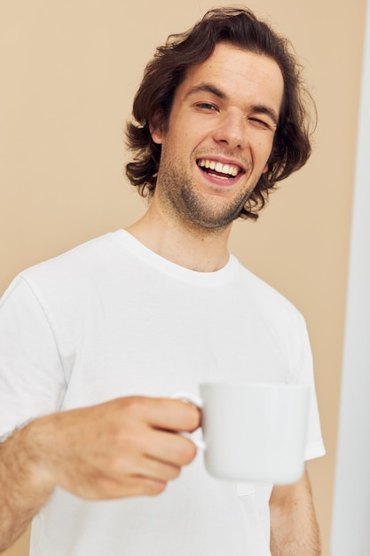 Hombre guapo con una taza blanca en sus manos emociones posando fondo aislado