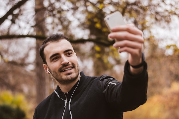 Hombre guapo toma un selfie fuera