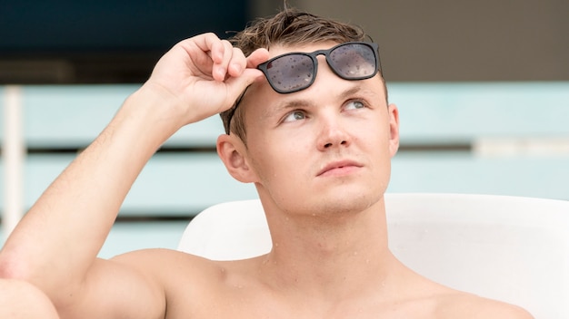 Hombre guapo en topless con gafas de sol.