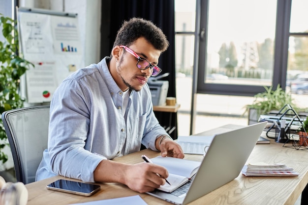 Hombre guapo trabajando diligentemente en su escritorio moderno con luz natural entrando