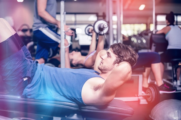 Foto hombre guapo trabajando sus abdominales en el gimnasio