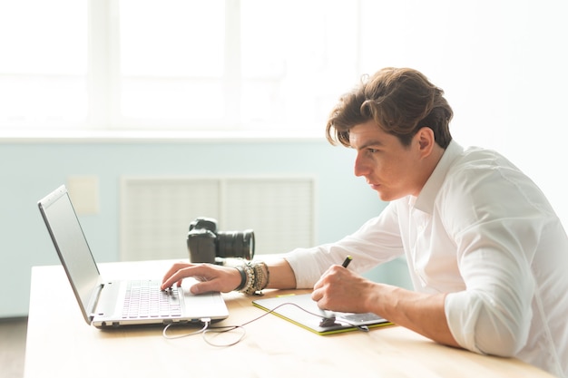 Hombre guapo trabajando con tableta gráfica