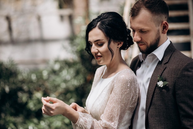 Hombre guapo con traje abrazando a mujer con vestido de novia